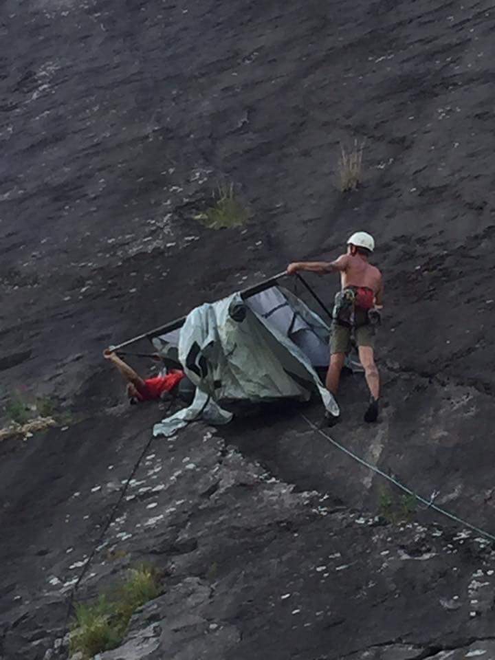 Climbers setting up a portaledge on a cliff face